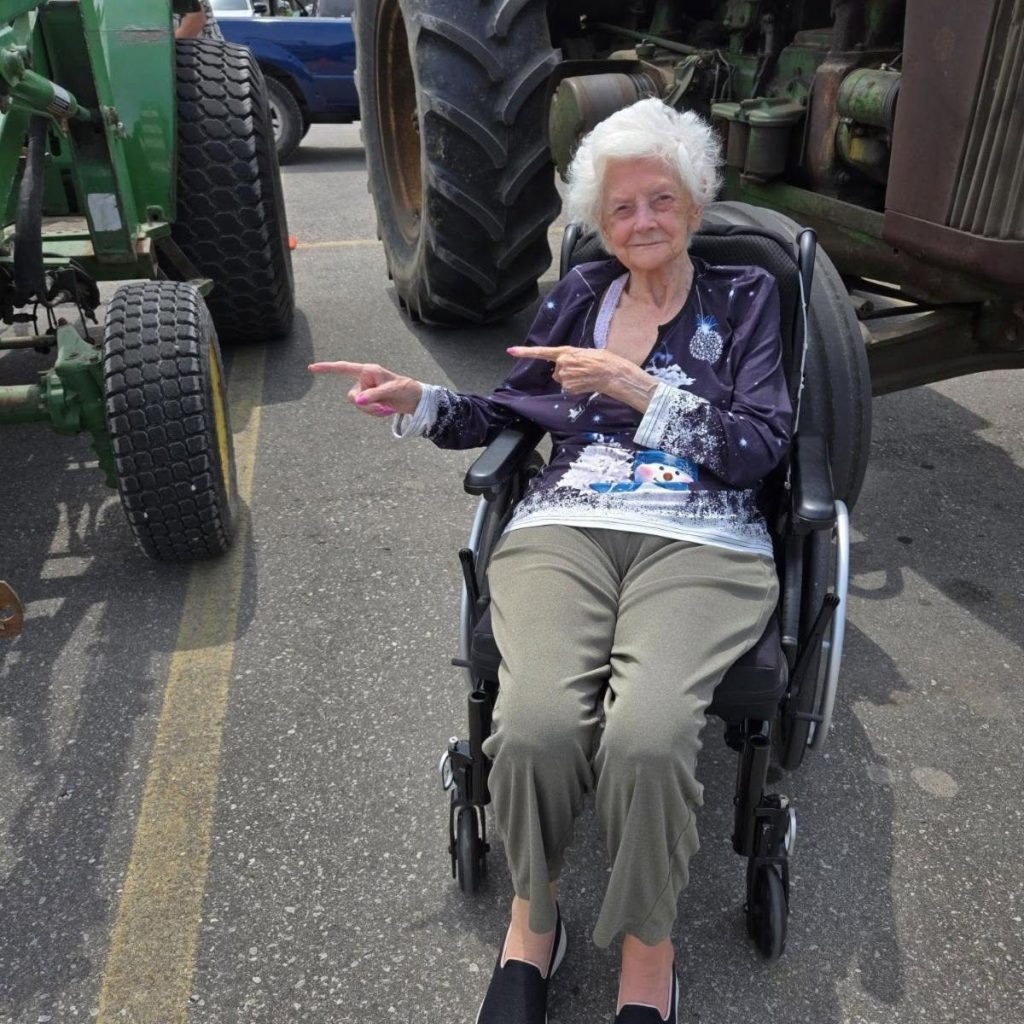 A resident pointing towards the vintage tractors on display